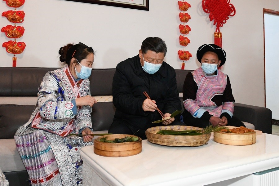2021年2月3日下午，習(xí)近平在貴州畢節(jié)市黔西縣新仁苗族鄉(xiāng)化屋村苗族村民趙玉學(xué)家，同一家人邊聊家常邊制作當(dāng)?shù)貍鹘y(tǒng)節(jié)日食品黃粑。新華社記者 李學(xué)仁 攝
