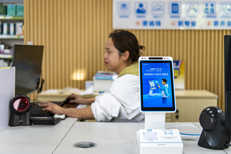 2024年4月10日，浙江金華市區(qū)一家民眾大藥房柜臺(tái)上設(shè)置著醫(yī)?！八⒛樦Ц丁睓C(jī)器，群眾看病更加便利。